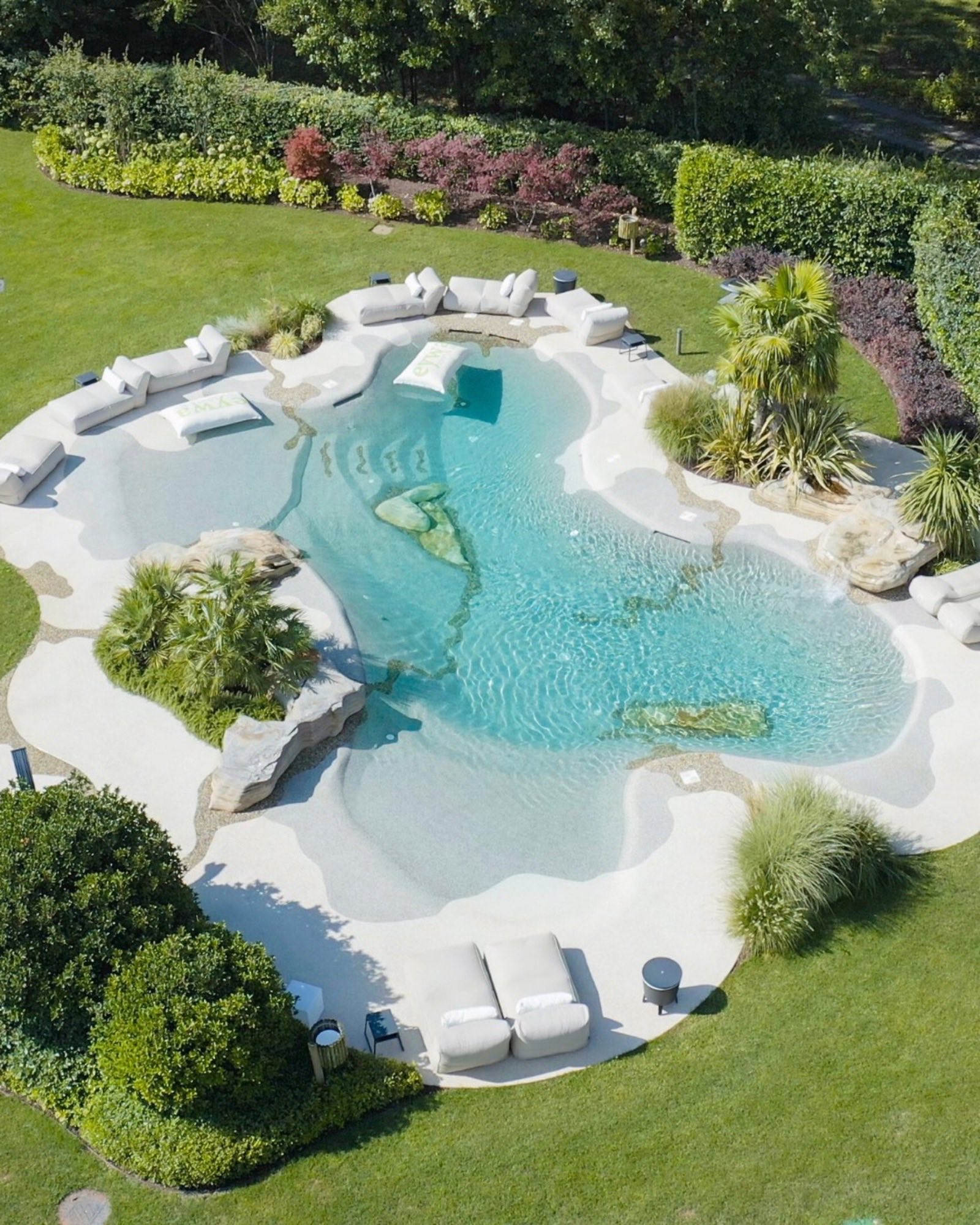 BioDesign Pool mit organischer Form und Relaxbereichen